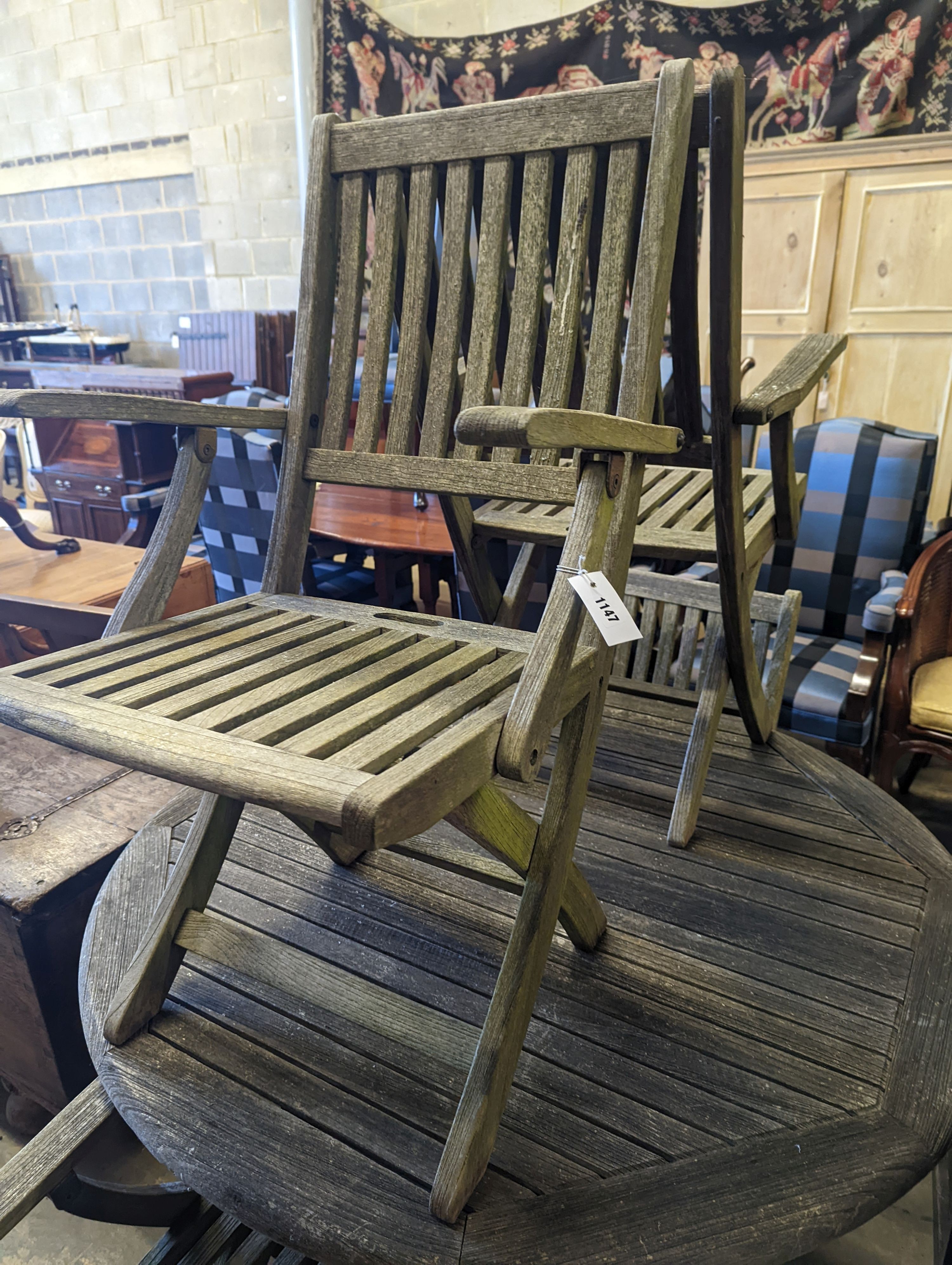 A set of four Westminster teak folding elbow chairs and a weathered teak circular garden table, diameter 120cm, height 73cm